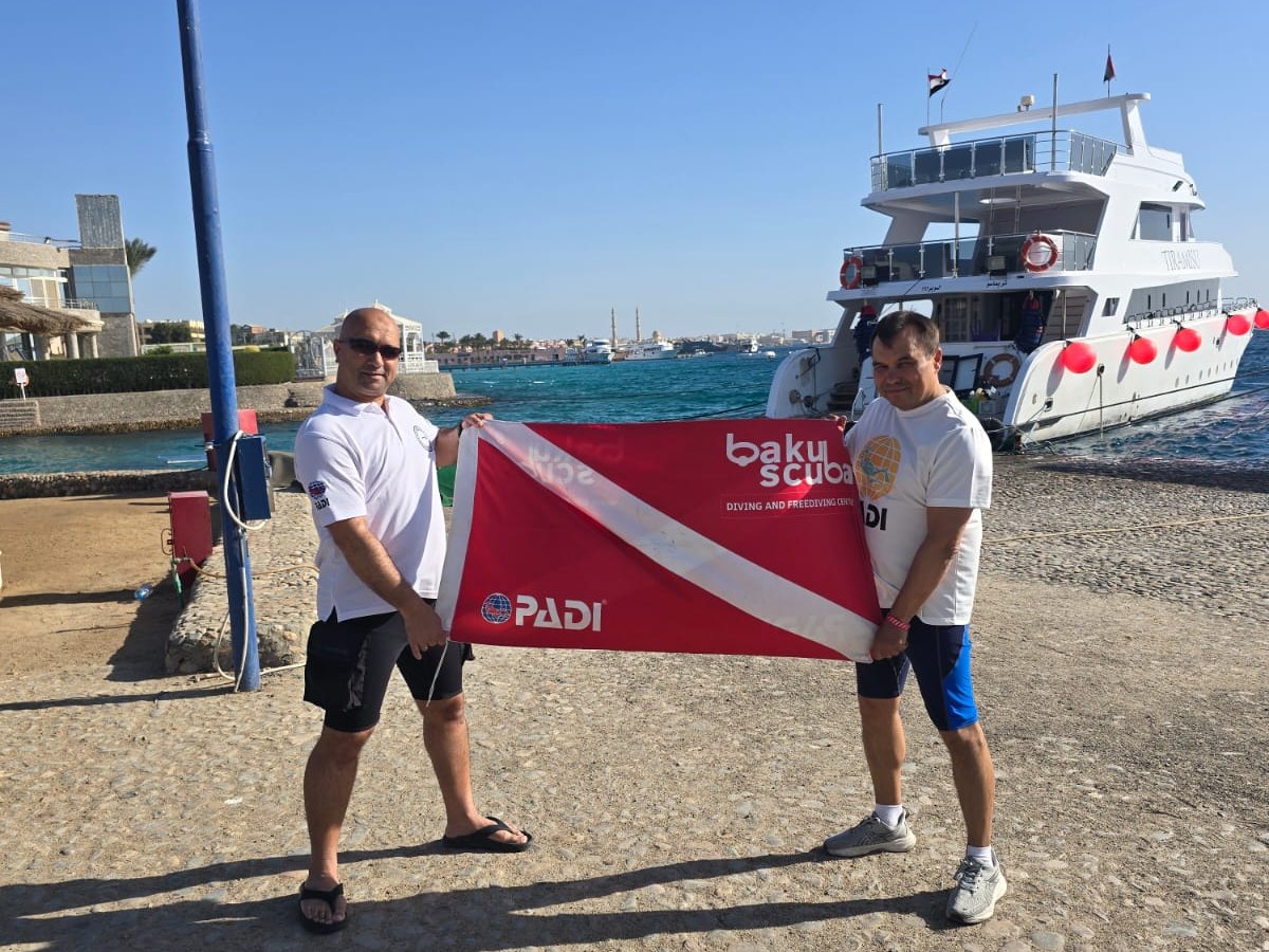 Дайверы Baku Scuba с флагом клуба в дайв-поездке